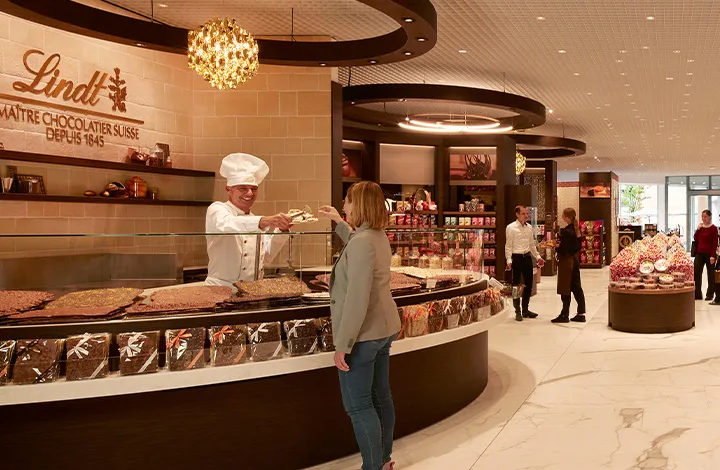 A real Lindt Master Chocolatier inspects a freshly made chocolate bar A real Lindt Master Chocolatier inspects a freshly made chocolate bar
